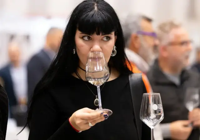 Γυναίκα στην οινική εκδήλωση δοκιμάζει κρασί